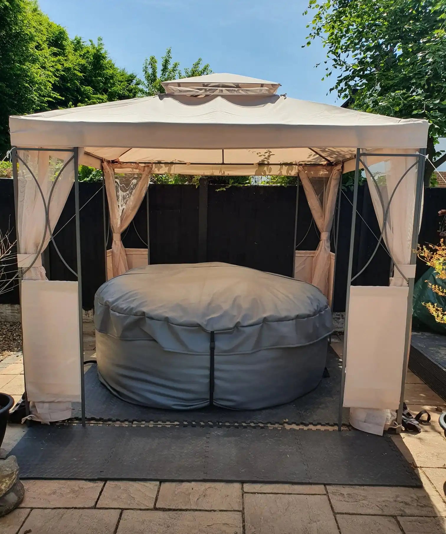 Covered hot tub under a gazebo.
